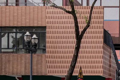 This architectural image showcases a building facade with a distinctive brickwork pattern. The facad