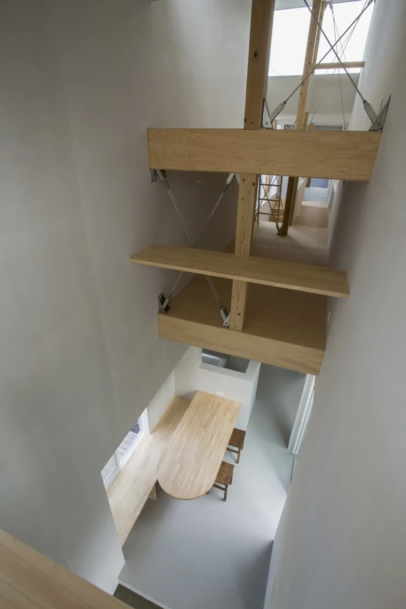 View down through timber platforms and cable bracing to a dining area below