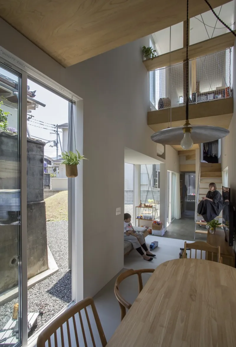 Living area with sliding glass doors to gravel courtyard and two children seated on floor