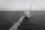 This architectural image showcases a modern pier extending into the sea, featuring a white, cylindri