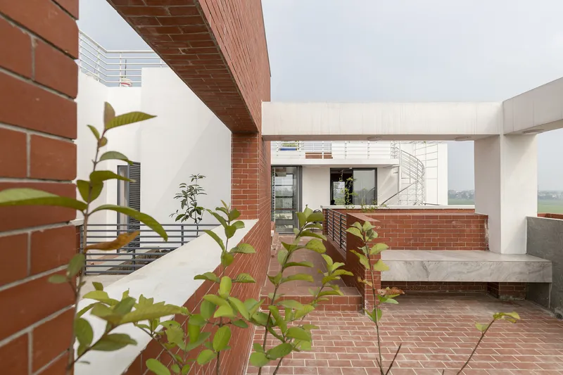 Upper level terrace with brick walls, exposed brick soffit, and plantings looking toward interior staircase