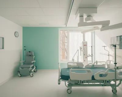 This architectural image showcases a modern hospital room designed for patient care. The room featur