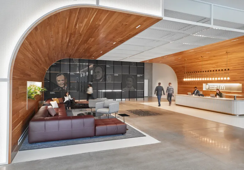 Reception lobby with curved timber ceiling and modular seating beneath a portrait wall