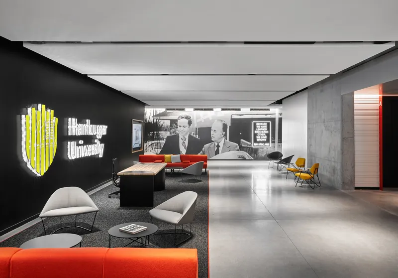 Reception area with black wall graphics and polished concrete floor beside a cast concrete column