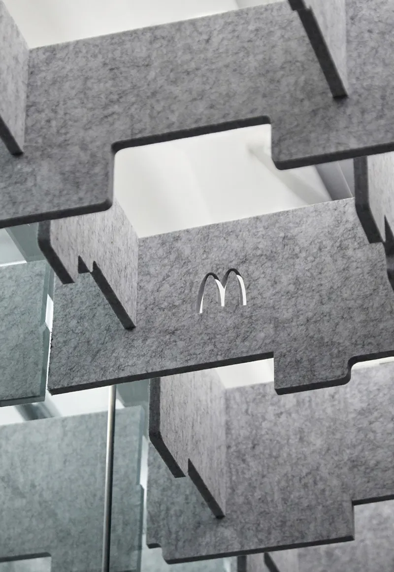 Close-up of interlocking grey felt acoustic panels with embossed logo detail