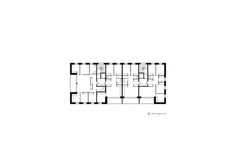 Floor plan drawing showing a rectangular building with multiple residential units and two staircases