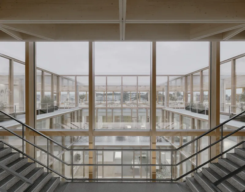 Symmetrical view through the timber-framed atrium windows to the landscaped courtyard below