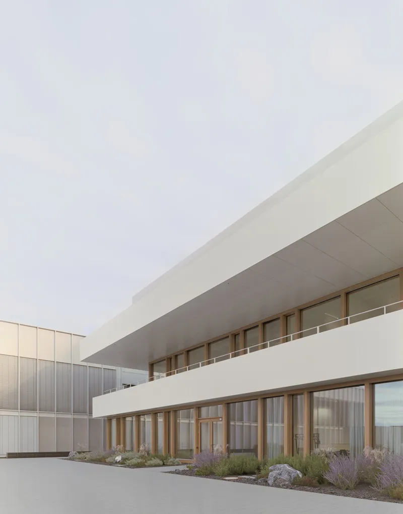 Entrance courtyard with stacked horizontal volumes and planted terraces beside a metal-clad adjacent wing