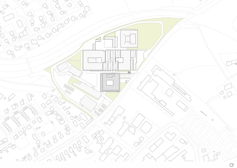 Site plan drawing showing building footprints, green perimeter landscaping, and surrounding neighborhood context