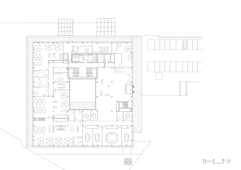 Floor plan drawing showing office spaces wrapping around a central void with exterior terraces