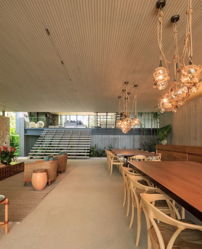 Dining and stair: floating concrete staircase, cluster of glass bubble pendant lights, timber table, wishbone chairs