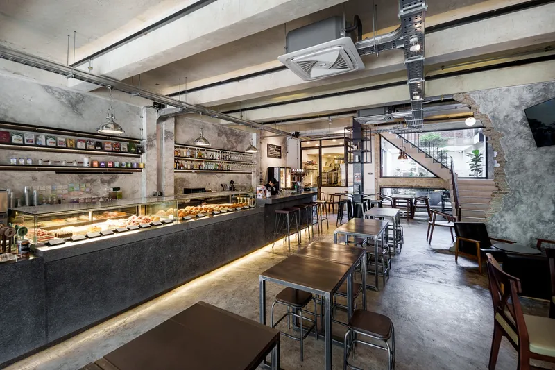 Light well: removed rear balcony revealing exposed brick, concrete beams, potted tree, glass door to interior