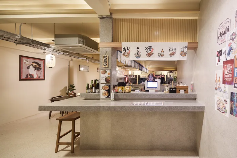 JIM's Recipe bar corner: concrete counter, timber stool, Japanese-style wall graphics, slatted ceiling