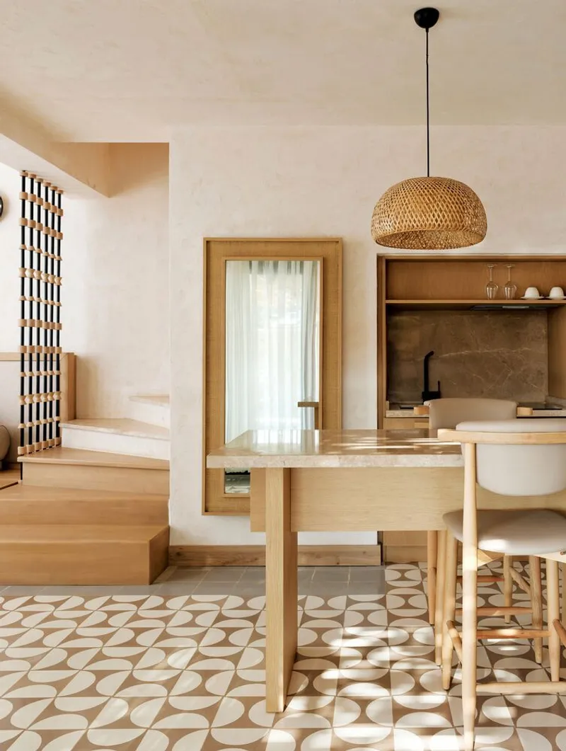 Dining area with patterned floor tile and timber table beneath woven pendant light fixture