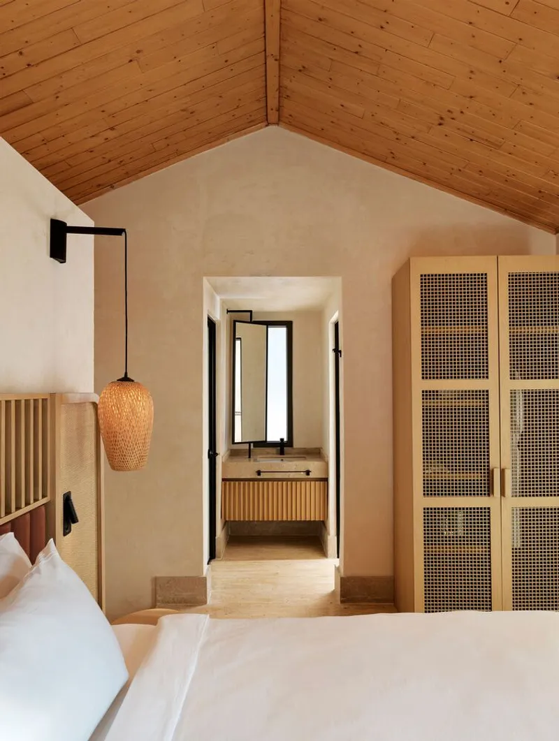 Bedroom view through arched doorway to ensuite bathroom with timber slat ceiling overhead