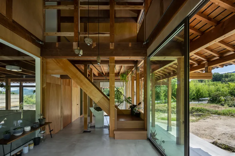 Interior view of the timber staircase and mezzanine level with glazed doors opening to landscape