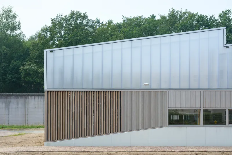 Facade detail: polycarbonate panels above vertical timber slat screen at ground level