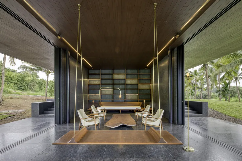 Suspended timber platform with built-in seating beneath brass rods and linear ceiling lights