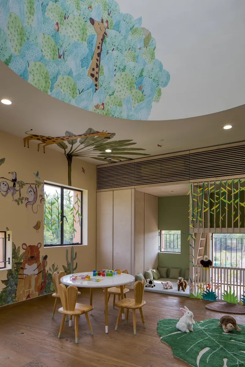 Circular play room with hand-painted jungle ceiling mural and timber furniture under diffused daylight