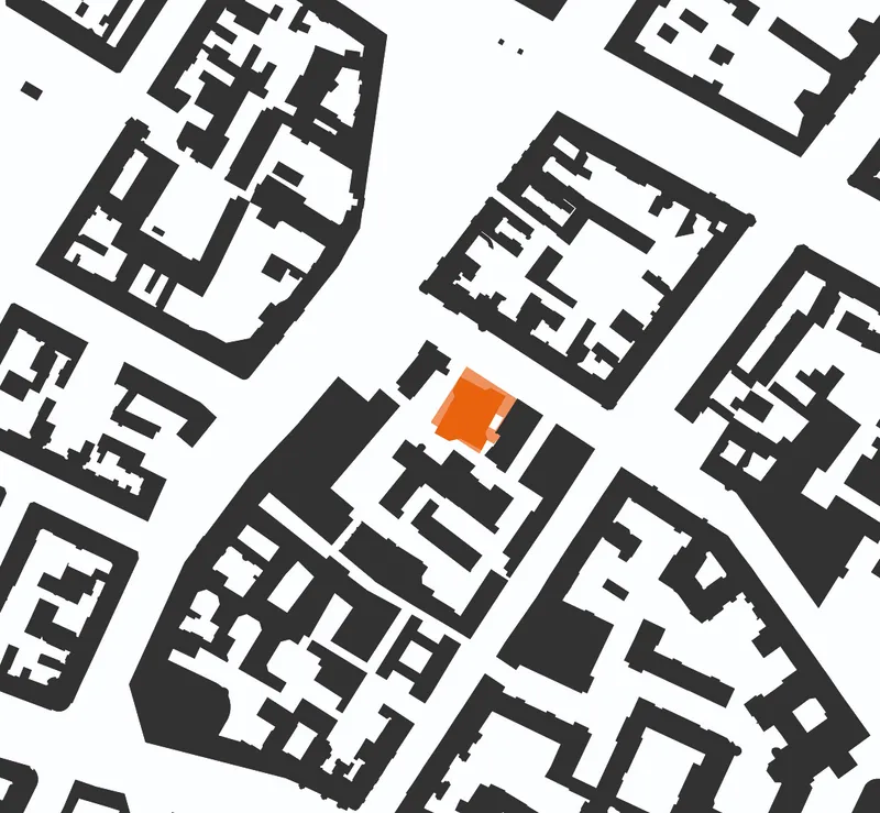 Site plan drawing with one building footprint highlighted in orange among surrounding urban blocks