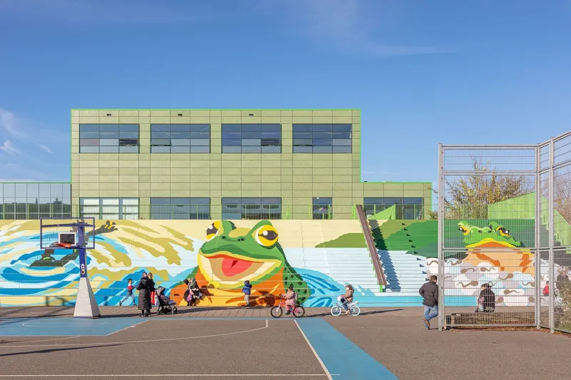 Terraced seating painted with frog murals and geometric patterns with children playing on bicycles