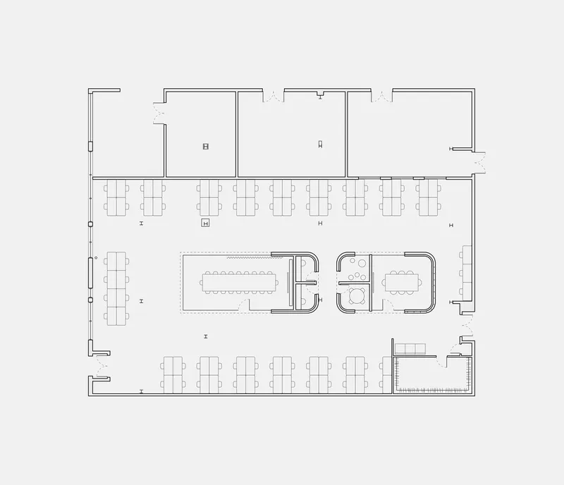 Floor plan drawing depicting workspace with central conference rooms flanked by individual workstations and restrooms