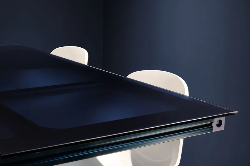 Close-up of dark table edge with ribbed blue detail against two white chair backs