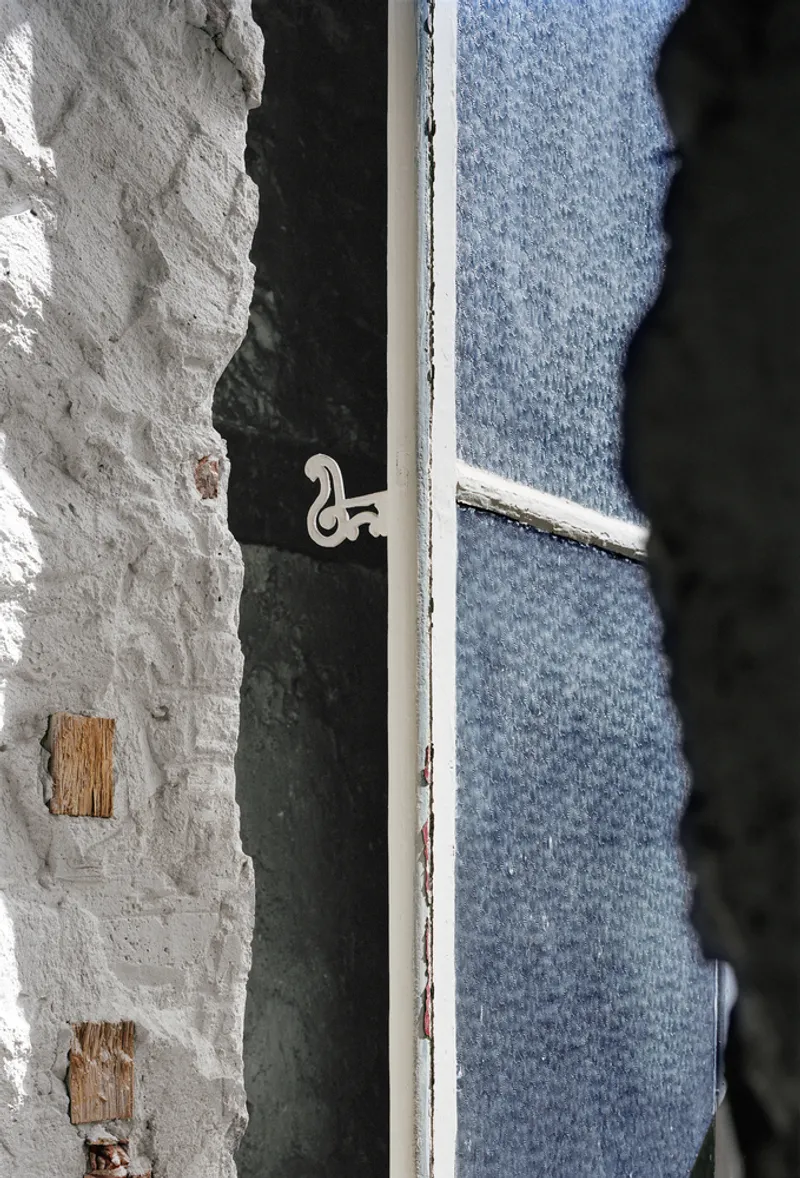 Before: close-up of window latch and mesh, masonry wall edge