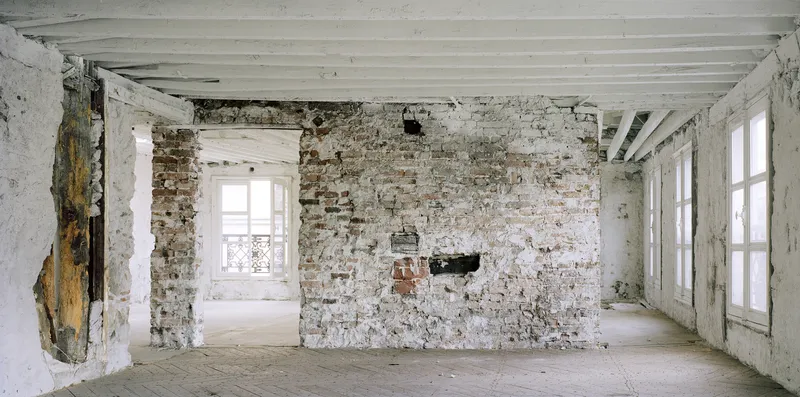 Before: upper floor, thick masonry arches, iron staircase spiral, exposed services