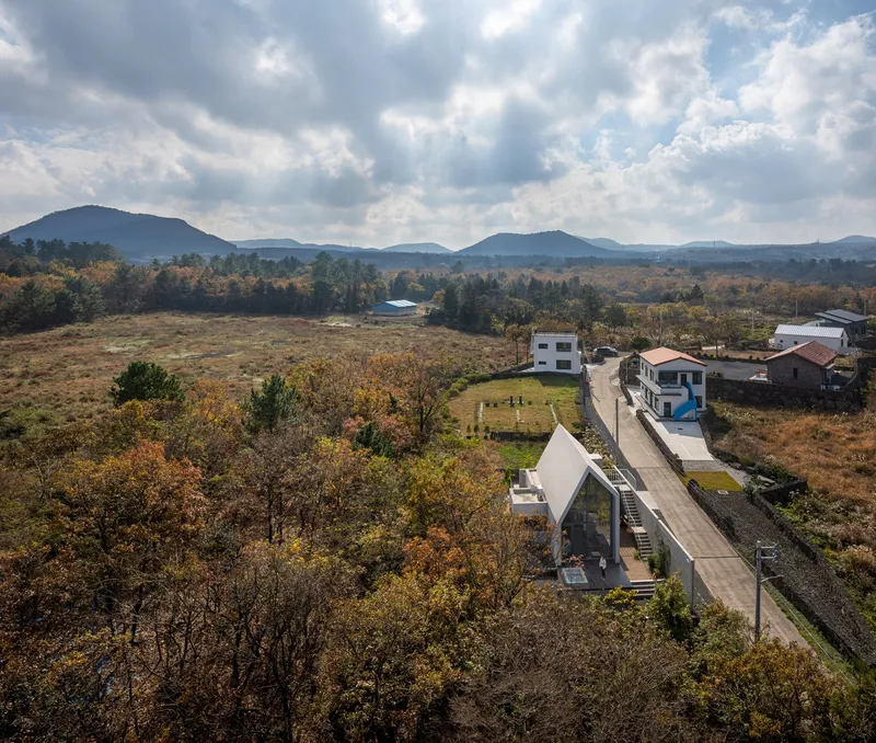 Drone perspective of the residence and concrete boundary wall in rural autumn landscape with distant peaks
