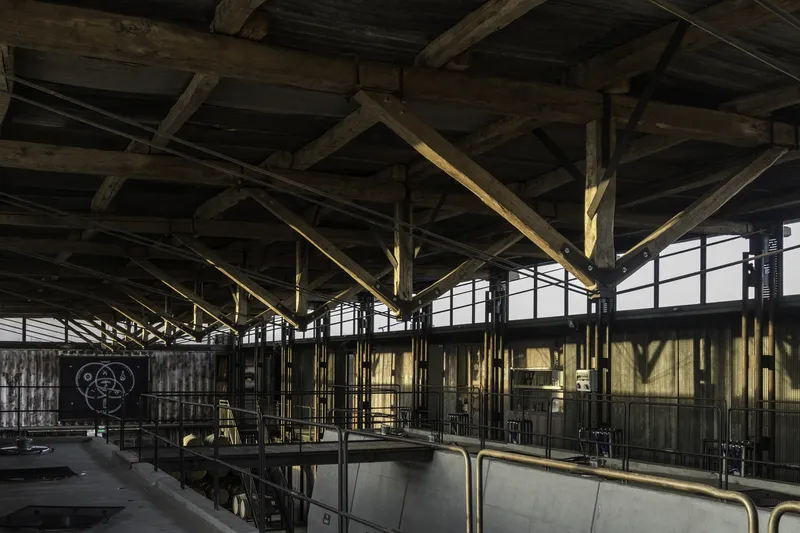 Production hall with heavy timber post and beam structure and clerestory glazing above steel fermentation tanks