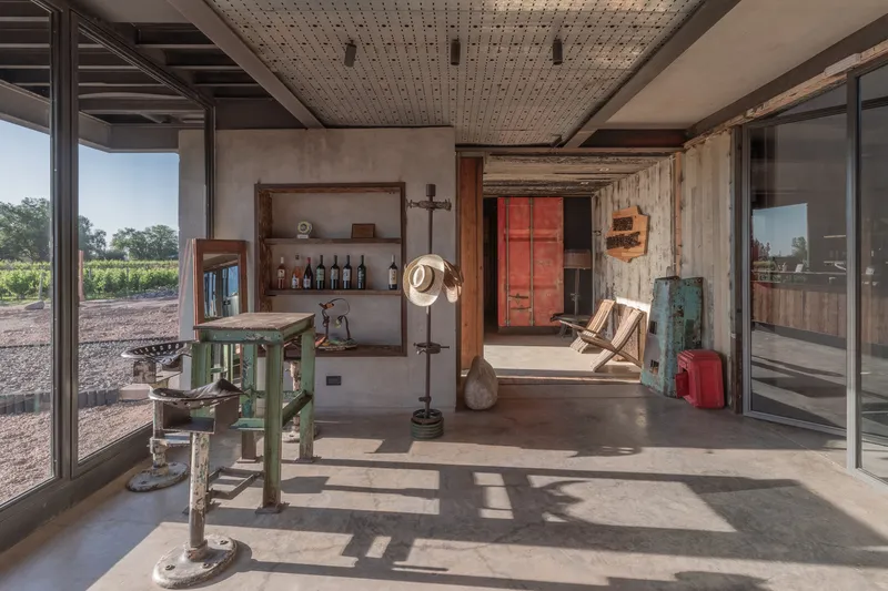 Covered terrace with perforated ceiling, reclaimed timber walls and sliding glass doors opening to vineyards