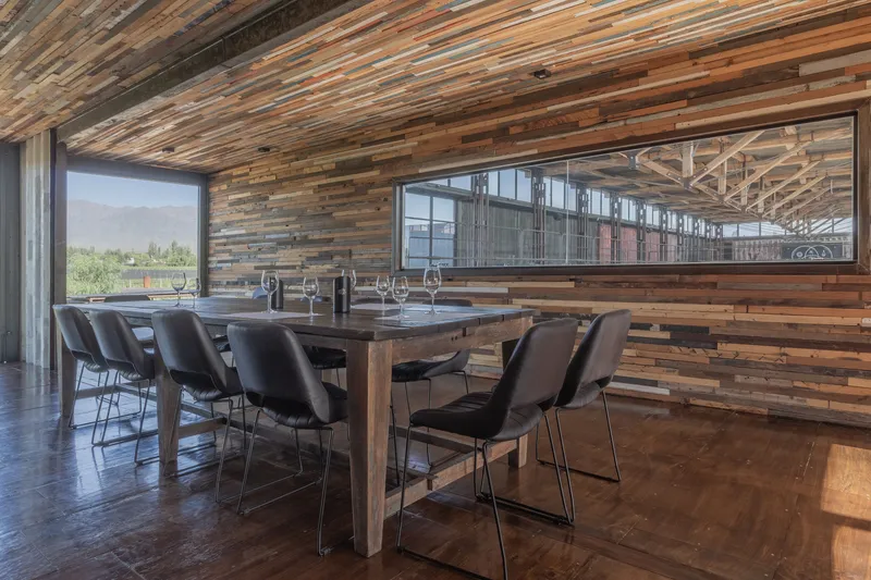Dining room with reclaimed wood plank ceiling and walls, clerestory windows overlooking production area