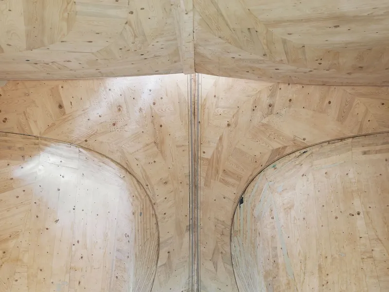 Interior view of laminated plywood ceiling with curved vaulted bays meeting at a central ridge