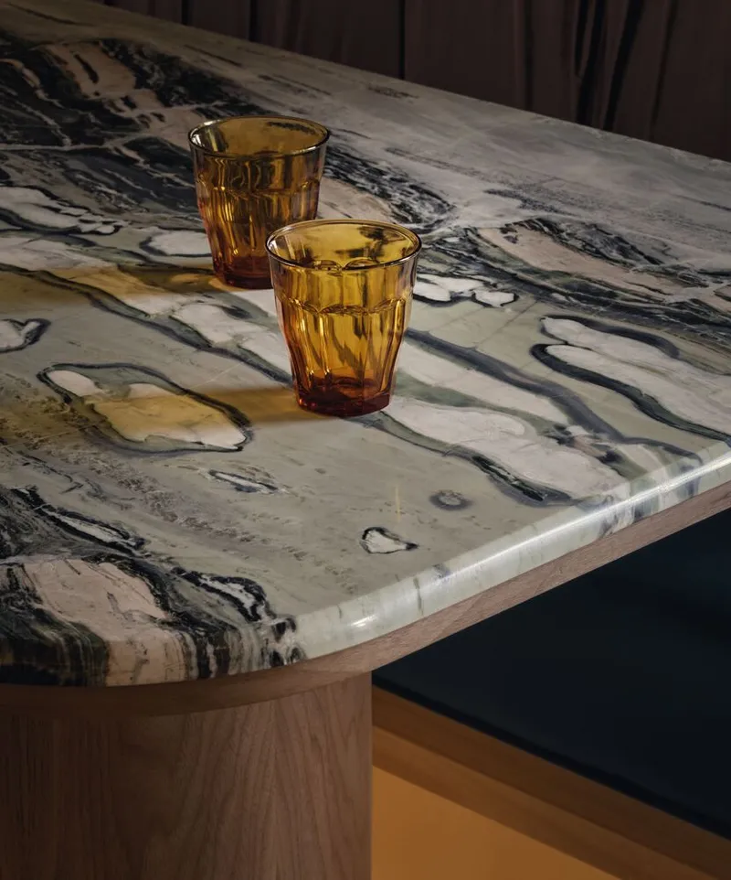 Close-up of amber glassware on a swirled black and white marble tabletop