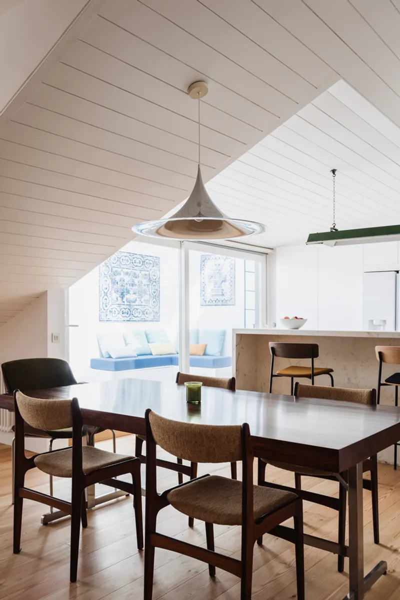 Dining area with dark wood table and pendant light beneath vaulted wood plank ceiling