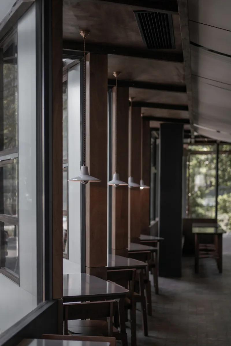 Entry vestibule: timber doors, glass partitions, timber posts, bar stools at the window