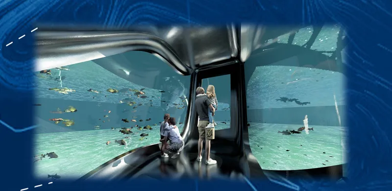 Underwater viewing chamber with curved glass walls where visitors observe fish and rays in turquoise water