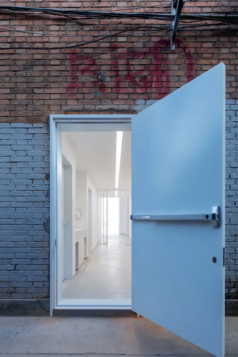 Corridor and bridge: second-floor passage overlooking the ground floor, skylights, tall windows to the trees outside