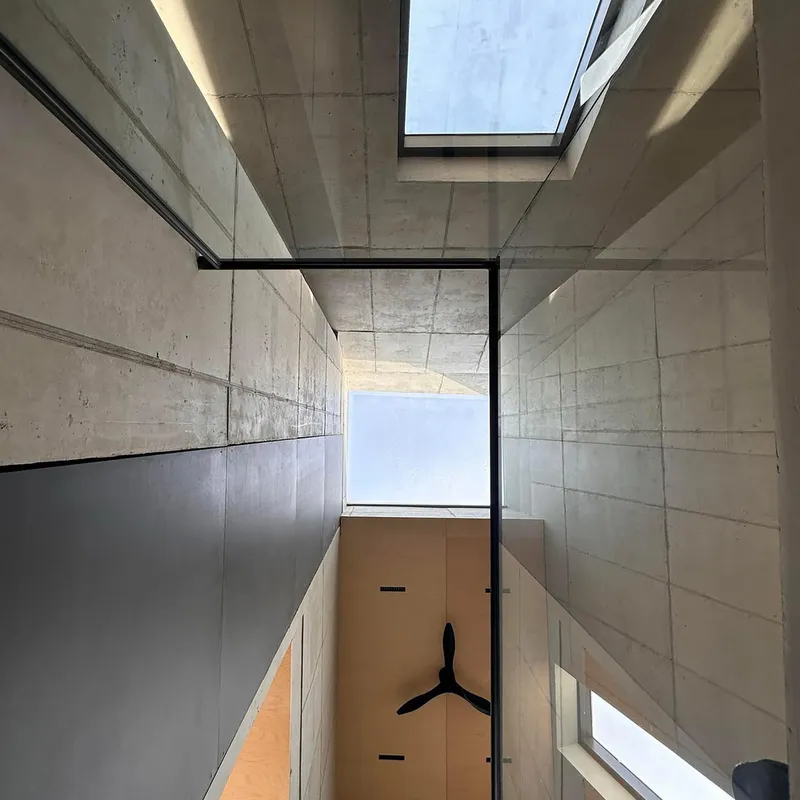 Basement: exposed concrete block walls, metal railing stair, linear lighting, utility/parking level