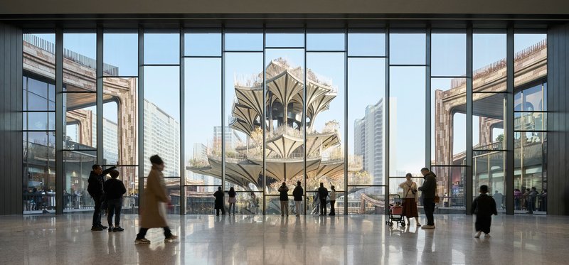 Interior concourse with floor-to-ceiling glazing overlooking the tiered structure and surrounding bridges