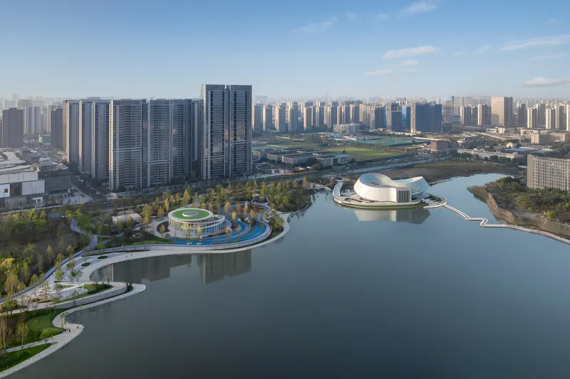 Wide aerial view showing the island development with pedestrian bridges extending into the lake