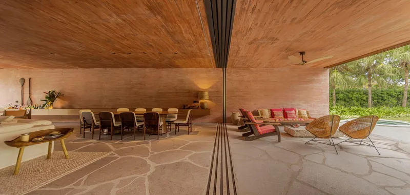 Living and dining area with vaulted timber ceiling and central metal column under afternoon light