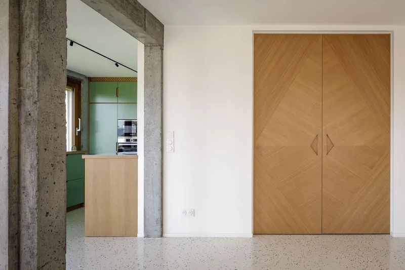 Joinery detail: oak door with chevron veneer pattern and diamond-shaped timber handles, concrete column beside