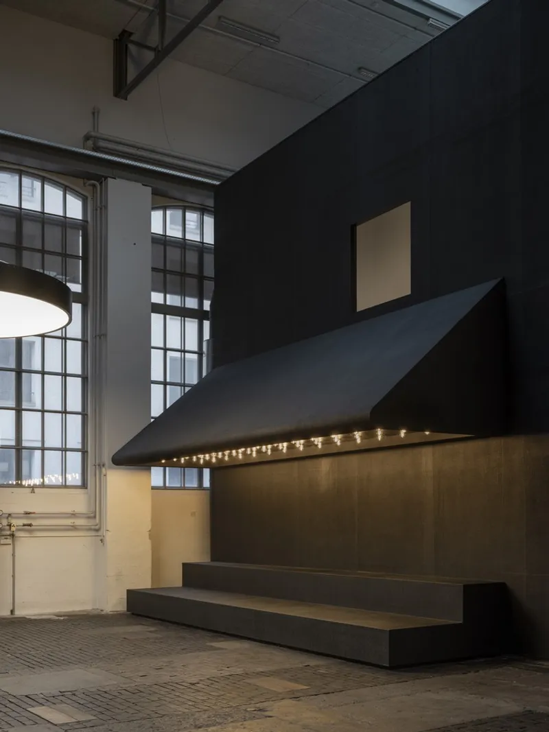 Reception counter with cantilevered canopy and integrated lighting beneath exposed ductwork