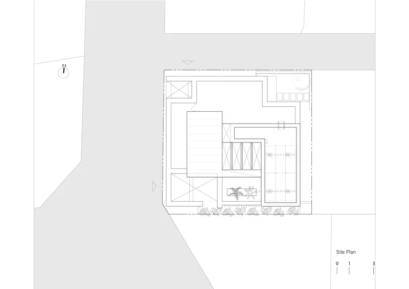 Site plan drawing showing a rectangular building with a central courtyard and diagonal site boundary