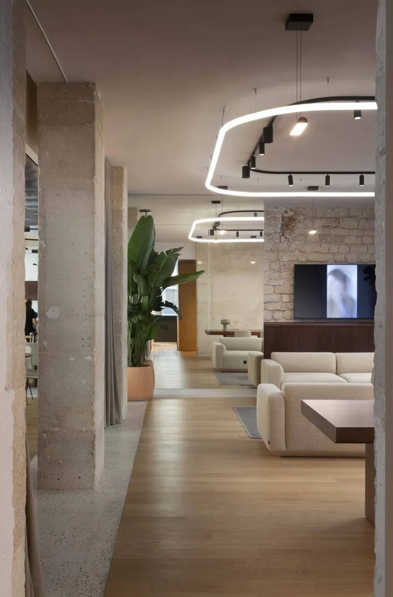 Concrete columns framing a lounge space with curved lighting elements and potted plants