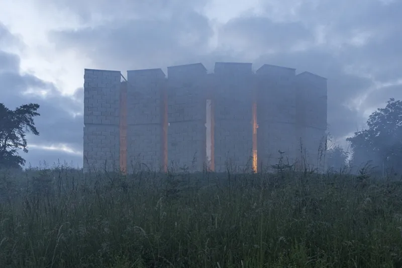 Misty dusk: chapel partly obscured by fog, glowing through the mist