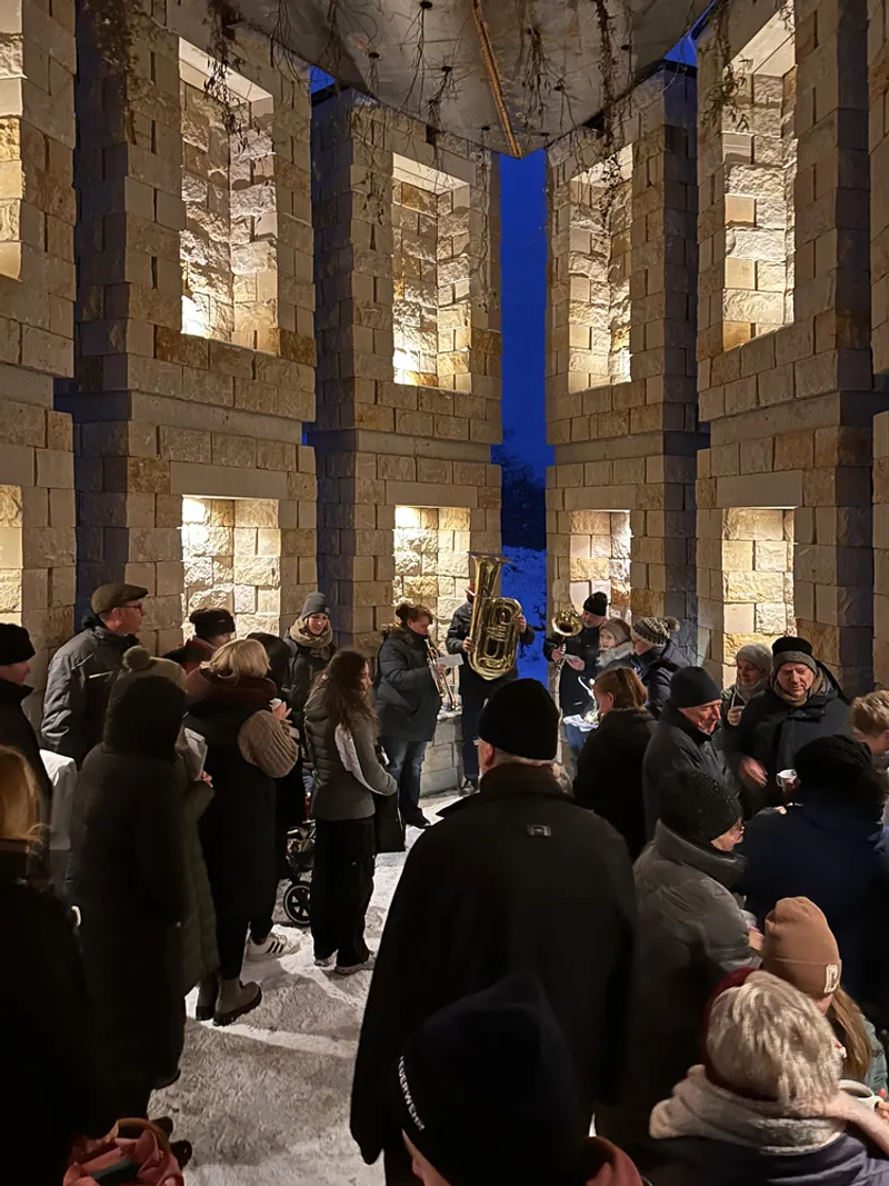 Winter ceremony inside the chapel: people gathered, blue colour-wash lighting, choir, intimate atmosphere
