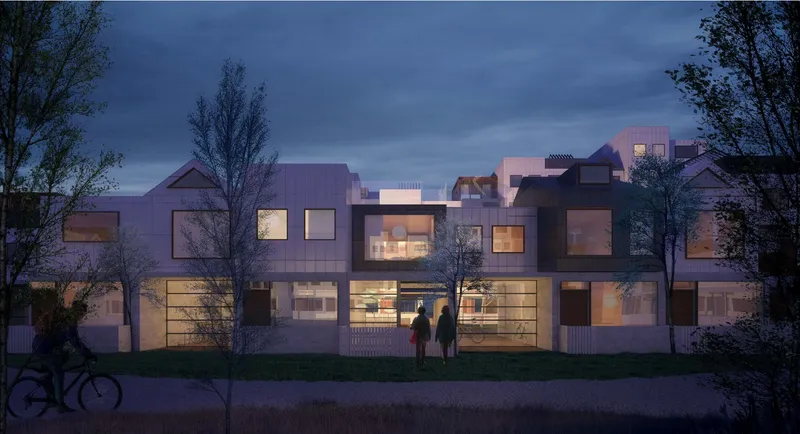 Street-facing elevation at night: warmly lit windows in a composition of varied rooflines and facade materials, with a cyclist, a couple, and trees in the foreground